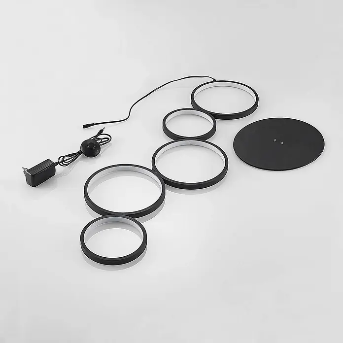 Lindby LED Stehlampe Wohnzimmer in schwarz, Stehleuchte -  - Demontierte schwarze runde LED-Leuchtenkomponenten: Ringe, runde Basis, Netzteil und Schalter.