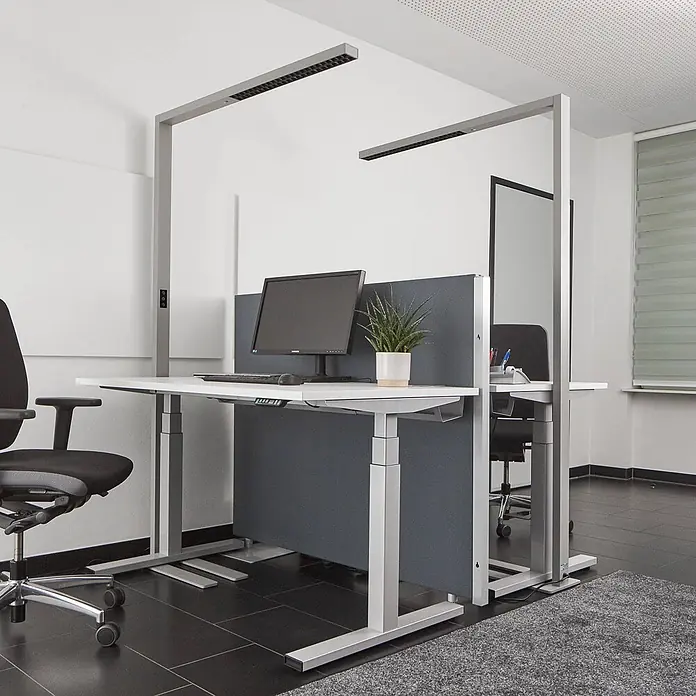 Arcchio LED Büro Stehlampe dimmbar, Bewegungsmelder, Tageslichtsensor -  - Moderne Steh-Sitz-Arbeitsplätze mit integrierter Deckenbeleuchtung und grauen Sichtschutzwänden, für zwei Nutzer im Büro.