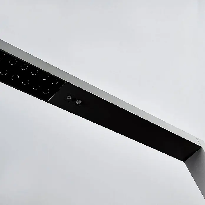 Arcchio LED Büro Stehlampe dimmbar, Bewegungsmelder, Tageslichtsensor -  - Nahaufnahme eines modernen silber-schwarzen LED-Lampenarms mit runden Lichtquellen und Sensoren.