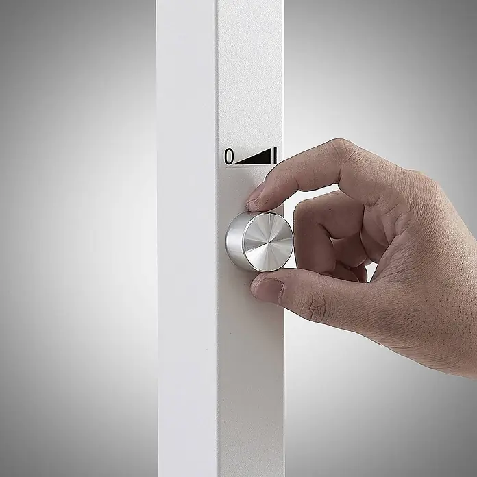 Arcchio LED Büro Stehlampe dimmbar, Bewegungsmelder, Tageslichtsensor -  - Hand dreht silbernen Metall-Drehregler an einer weißen Platte mit Skala von 0 aufwärts.