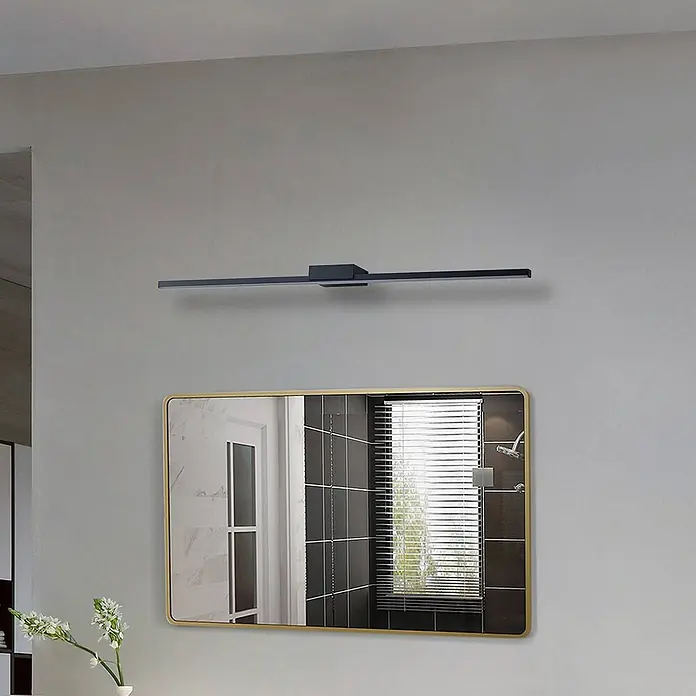 Lucande LED Wandleuchte innen in schwarz, Wandlampe -  - Schwarze lineare LED-Spiegelleuchte über einem rechteckigen Spiegel mit Goldrahmen in einem modernen Badezimmer.