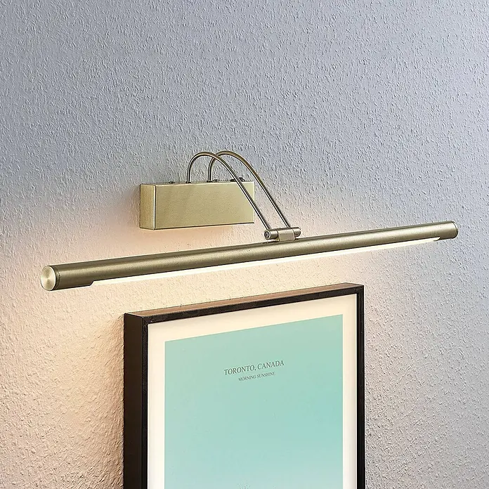 Lucande Bilderleuchte LED mit Schalter, Spiegelleuchte 69 cm -  - Mattgoldene LED-Bilderleuchte beleuchtet ein gerahmtes Poster an einer strukturierten Wand.