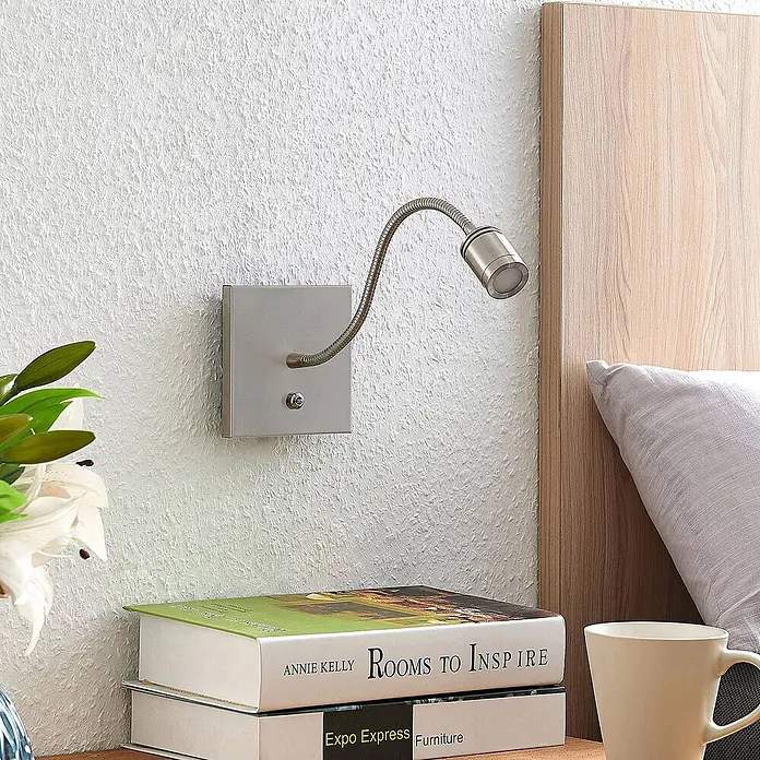 Lindby LED Wandleuchte innen in nickel satiniert, Wandlampe -  - Wandmontierte LED-Leselampe aus gebürstetem Metall mit flexiblem Arm, die einen Nachttischbereich beleuchtet.