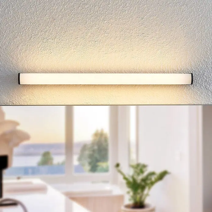 Lindby LED Wandleuchte innen in schwarz matt, weiß, Wandlampe -  - Horizontale lineare LED-Leuchte mit weißem Diffusor und schwarzen Enden, über einem Spiegel an strukturierter Wand montiert.
