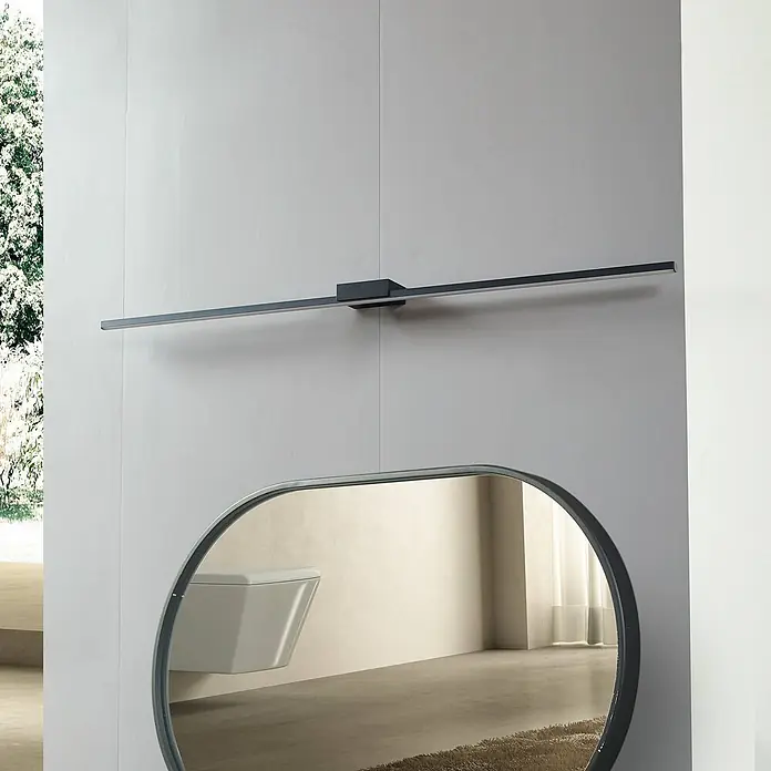 Lucande LED Wandleuchte innen in schwarz, Wandlampe -  - Schwarze lineare LED-Leuchte über einem ovalen Spiegel in einem modernen Badezimmer.