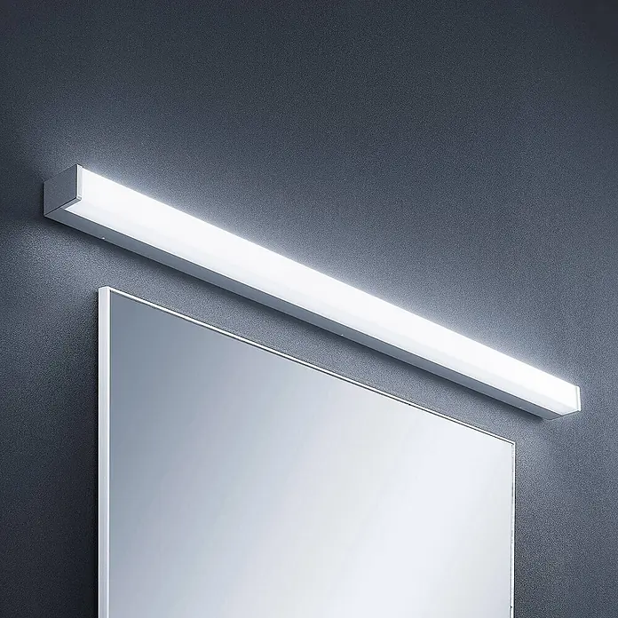 Lindby LED Wandleuchte innen in weiß, chrom, up down Wandlampe -  - Silberne lineare LED-Spiegelleuchte mit weißem Diffusor, horizontal über einem Spiegel an einer dunklen Wand montiert.
