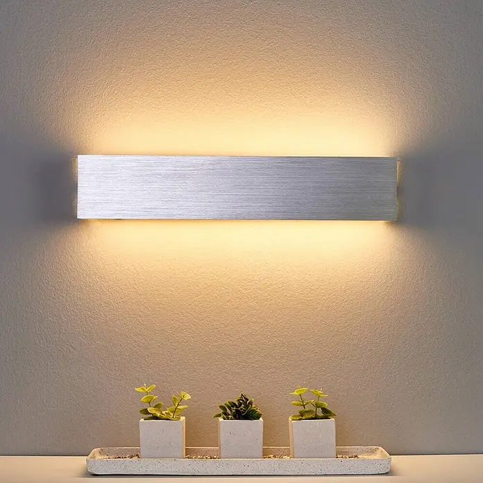 Lindby Wandleuchte Ranik - alu / grau / zink, alu / grau / zink - Rechteckige Wandleuchte aus gebürstetem Aluminium, die eine strukturierte Wand nach oben und unten warm beleuchtet.