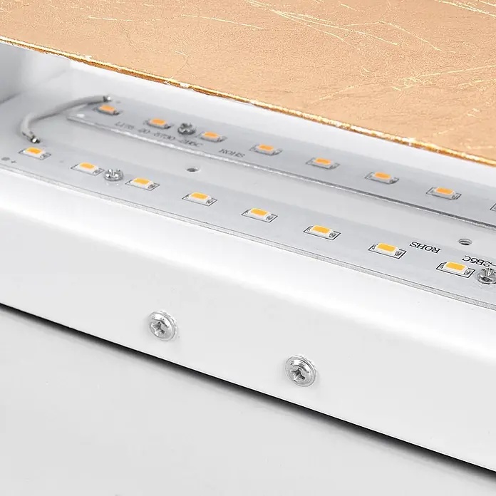 Lindby LED Wandlampe goldfarben, Uplight and Downlight Effekt, 1x 10W LED -  - Nahaufnahme von LED-Lichtleisten mit orangefarbenen Emittern in einem weißen Gehäuse, Befestigungsschrauben und goldener Strukturplatte.