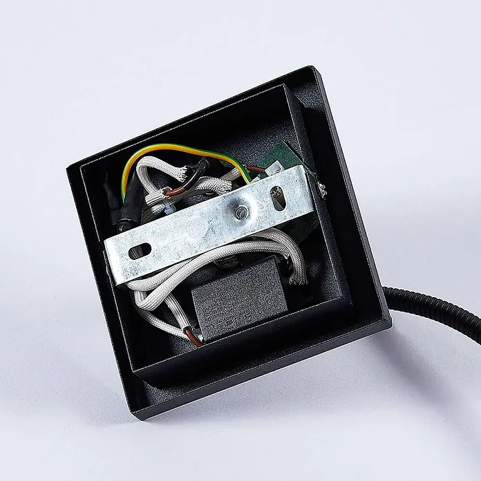 Lindby LED Wandleuchte innen in schwarz, Wandlampe -  - Innenansicht einer schwarzen Elektroarmatur mit weißen geflochtenen Kabeln, gelb-grünem Erdungskabel, Metallhalterung und Anschluss an ein Wellrohr.