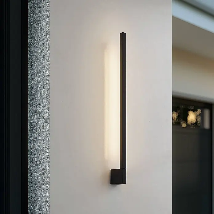 Lindby LED Wandleuchte aussen in schwarz, weiß, Aussenlampe Wand -  - Schwarze lineare Wandleuchte, vertikal montiert, beleuchtet die Wand mit warmem Licht.