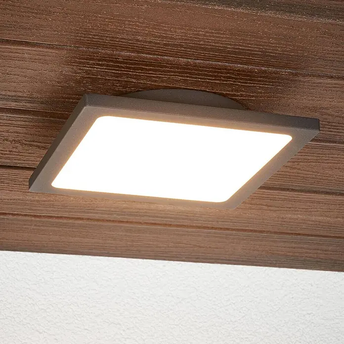 Lucande LED Outdoor Deckenlampe in anthrazit, weiß, mit Bewegungsmelder, -  - Beleuchtete quadratische dunkelgraue LED-Aufbauleuchte an einer Holzdecke.