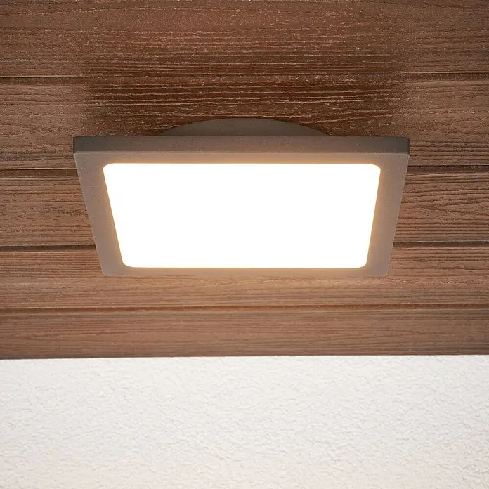 Lucande LED Outdoor Deckenlampe in anthrazit, weiß, mit Bewegungsmelder, -  - Quadratische LED-Deckenleuchte mit grauem Rahmen, montiert an einer braunen Holzdecke, spendet hellweißes Licht.