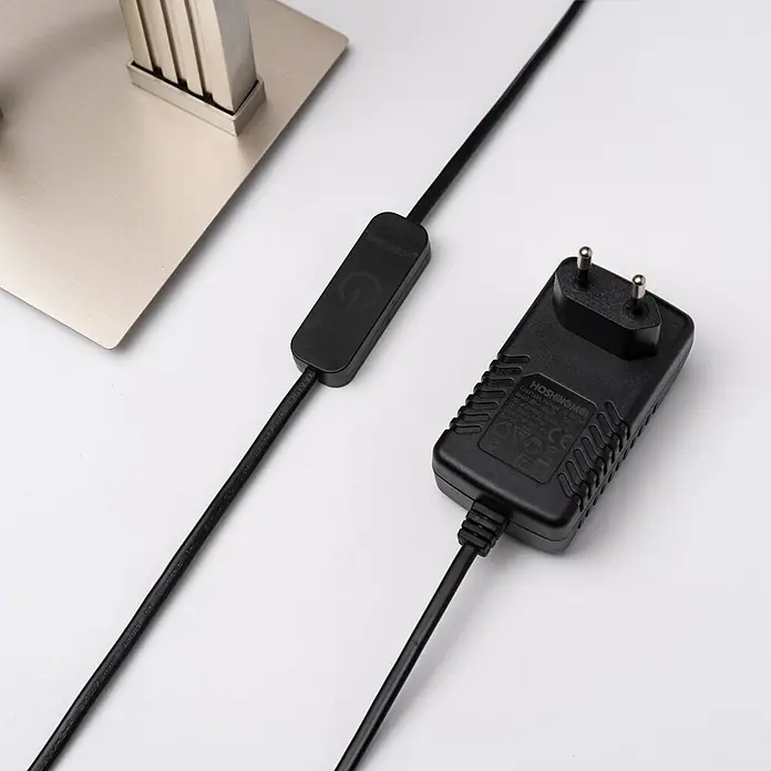 Lucande Stehleuchte Mairia - alu / grau / zink - Schwarzes Netzteil mit Eurostecker, Zwischenschalter und Kabel zu einem metallischen Lampenfuß.