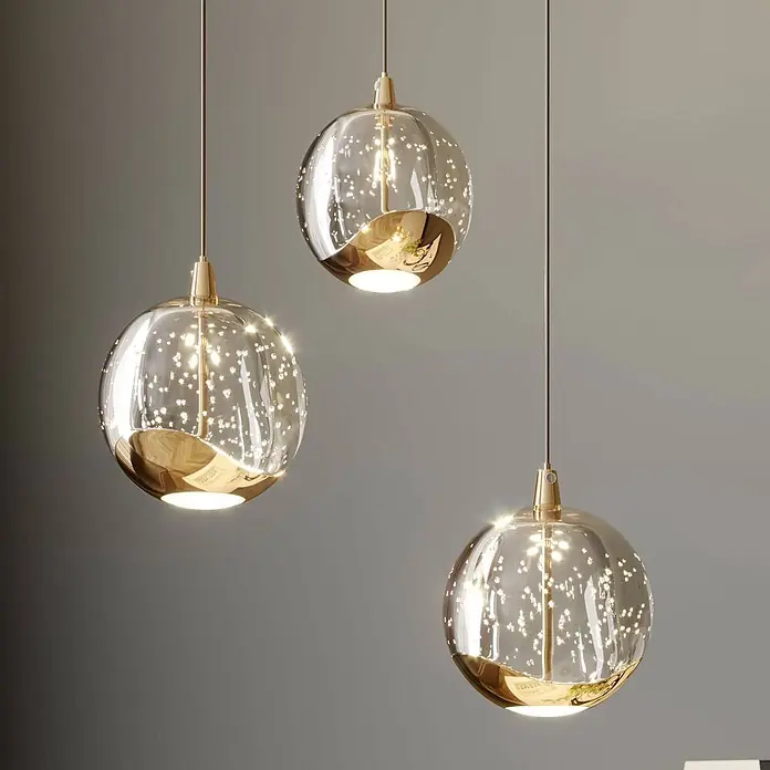 Lucande LED Pendelleuchte in transparent, gold, Hängelampe -  - Drei goldene und klare kugelförmige Pendelleuchten aus Glas mit funkelnden Innendetails.