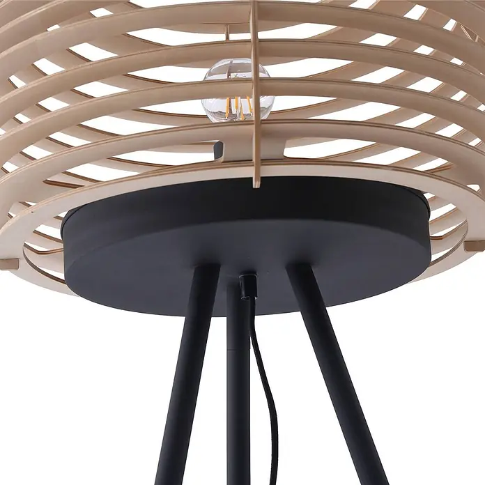 Lindby Stehlampe Wohnzimmer, Tripod in holz, schwarz, Stehleuchte -  - Eine Lampe mit hellem Holzlamellenschirm, schwarzem Metallfuß und Beinen. Eine freiliegende Glühbirne ist sichtbar.