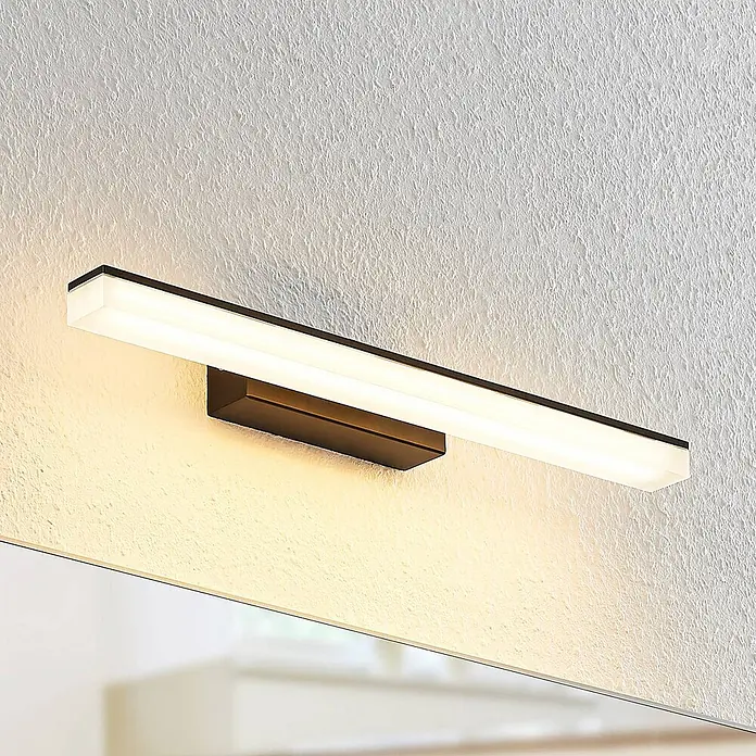 Lucande LED Wandleuchte innen in schwarz, weiß, Wandlampe -  - Dunkle lineare LED-Wandleuchte, strahlt warmweißes Licht aus, über einem Spiegel montiert.