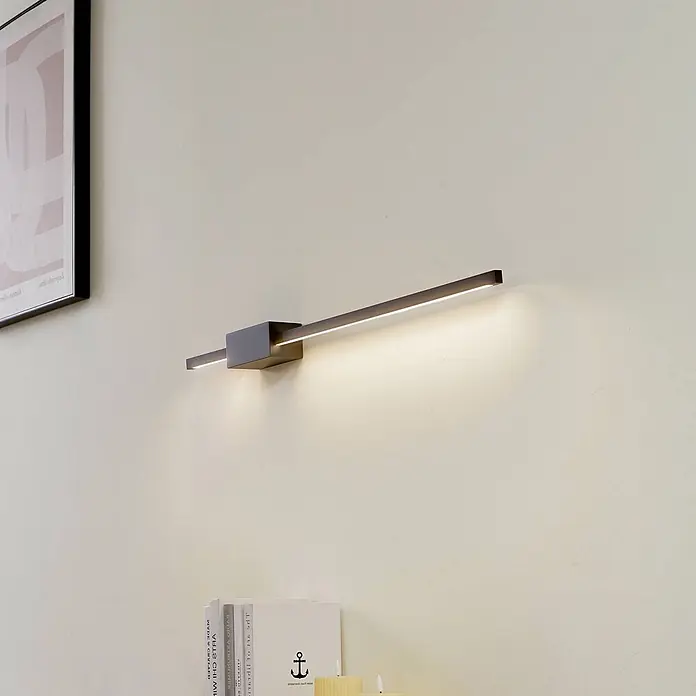 Lucande LED Wandleuchte innen in schwarz, up down Wandlampe -  - Moderne dunkle lineare LED-Wandleuchte an einer hellen Wand, die den Raum beleuchtet.