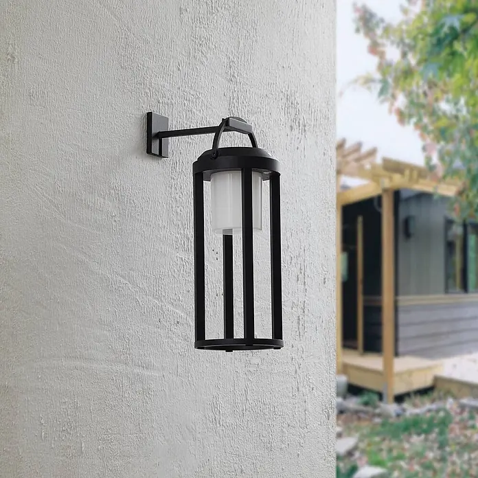Lucande LED Solar Wandleuchte aussen in schwarz, weiß, dimmbar Aussenlampe -  - Schwarze Außenwandleuchte mit mattiertem weißem Glasdiffusor, an einer strukturierten Wand montiert.