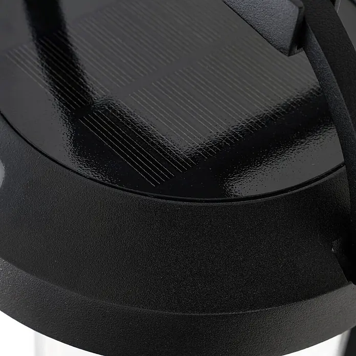 Lucande LED Solar Wandleuchte aussen in schwarz, weiß, dimmbar Aussenlampe -  - Nahaufnahme eines glänzenden schwarzen Solarpanels mit Gitterlinien, integriert in ein mattes schwarzes, strukturiertes Gerät.