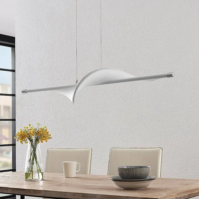 Lucande LED Pendelleuchte in weiß, chrom, Hängelampe -  - Moderne weiße lineare Pendelleuchte mit welligem Design, über einem Holztisch hängend.