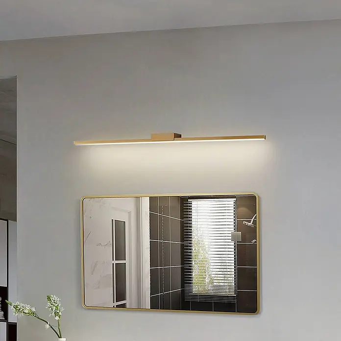 Lucande LED Wandleuchte innen in kupfer, Wandlampe -  - Goldfarbene lineare LED-Spiegelleuchte beleuchtet einen Badezimmerspiegel.