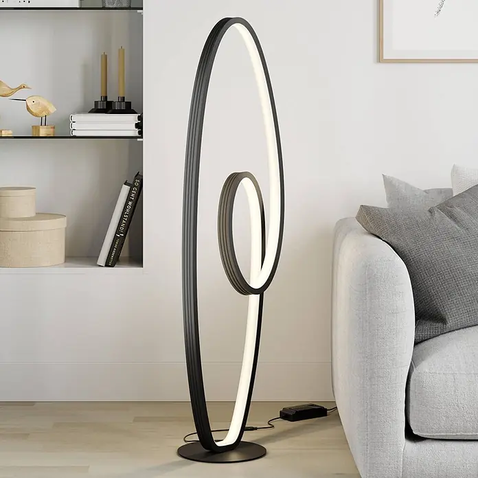 Lucande Stehleuchte Bronwyn - schwarz, schwarz - Moderne schwarze LED-Stehleuchte mit geschwungenem Design, die ein Wohnzimmer beleuchtet.
