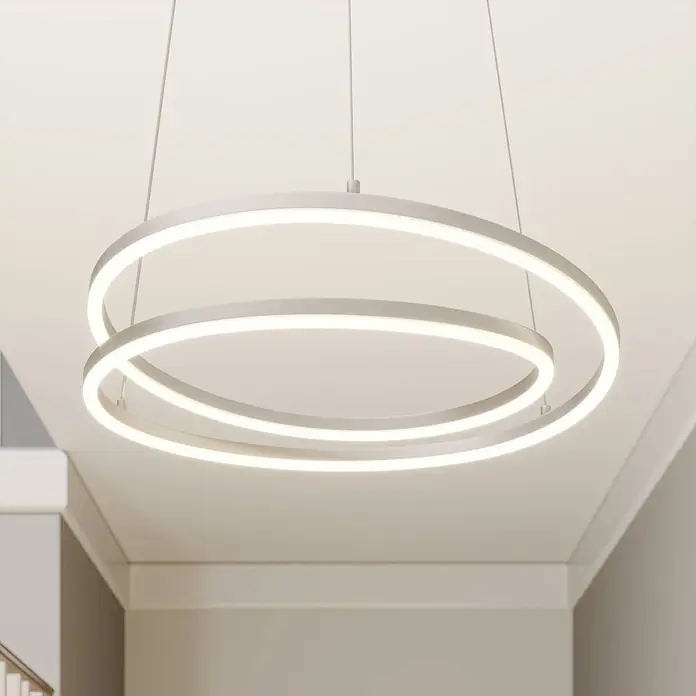 Lindby Pendelleuchte Davian - alu / grau / zink, nickel satiniert - Moderne weiße LED-Pendelleuchte mit zwei überlappenden Ringen, an der Decke hängend, die helles Licht abgibt.