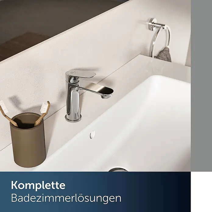 Ideal Standard Waschtischarmatur - Chrom, Hochglänzend - Verchromte Badezimmerarmatur auf weißem Waschbecken, daneben Zahnbürstenhalter und Handtuchring.