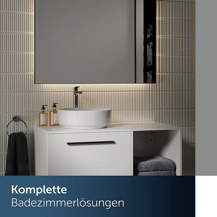 Ideal Standard Waschtischarmatur - Chrom, Hochglänzend - Moderne weiße Badmöbel mit rundem Waschbecken, Armatur und beleuchtetem Spiegel in gefliestem Bad. Mit Seifenspendern und Handtüchern.