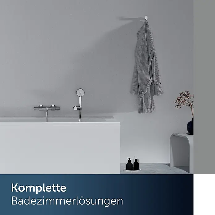 Ideal Standard UP-Thermostatarmatur - Chrom, Hochglänzend - Ein elegantes Badezimmer mit weißer Badewanne, Chrom-Duscharmaturen und einem grauen Bademantel, das umfassende Lösungen präsentiert.