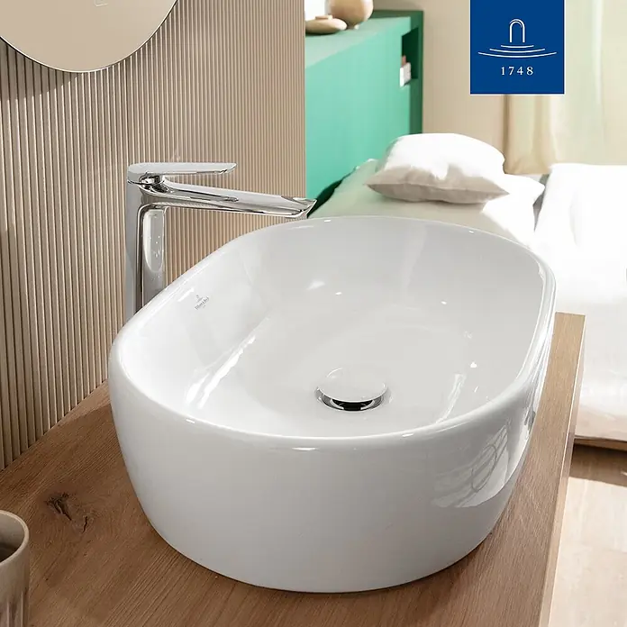 Villeroy & Boch Waschtischarmatur - Chrom, Hochglänzend - Weißes Keramik-Aufsatzwaschbecken mit Chromarmatur auf heller Holzplatte in einem modernen Badezimmer.