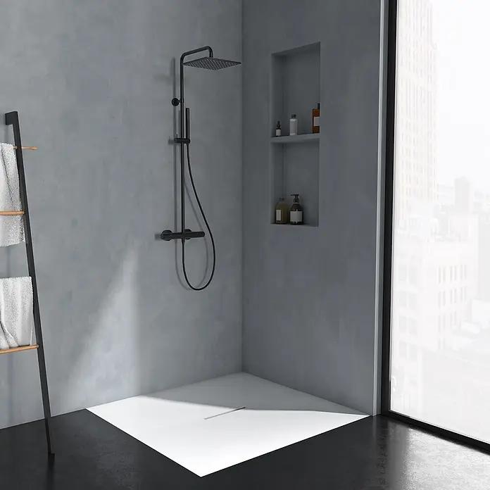 Ideal Standard Duschsystem - Anzahl Strahlarten: 2 Stk., Matt Schwarz - Eine moderne Eckdusche mit mattschwarzem Duschsystem, weißer Duschwanne und Handtuchleiter in einem dunkelgrauen Badezimmer mit Stadtblick.