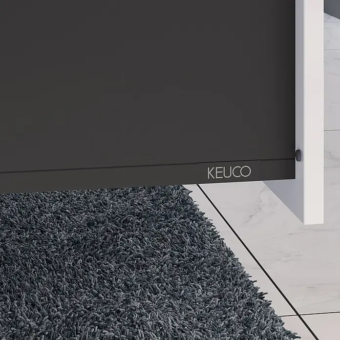 Keuco Badmöbel-Set 100 cm, mit Waschtisch und Unterbau, weiß - Gesamtbreite Badmöbel: 100,7 cm, Weiß, Seidenmatt - Dunkelgraues mattes Paneel mit 'KEUCO'-Logo, möglicherweise Duschwand, über grauem Teppich und weißen Fliesenboden.