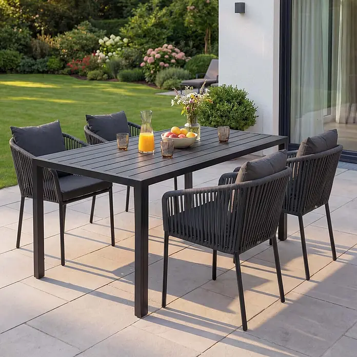 Mendler Gartenmöbel-Set HWC-N41 - 5 -tlg., Metall, Anthrazit, dunkelgrau, Anthrazit, Kissen dunkelgrau - Dunkelgraues Outdoor-Essgruppe mit geflochtenen Seilstühlen und Kissen, auf einer Terrasse zum Gebrauch bereit.
