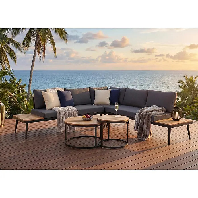 Mendler Loungemöbel-Set HWC-H54 - 3 -tlg., Holz, Hellbraun, Kissen dunkelgrau, Hellbraun, dunkelgrau - Outdoor-Ecksofa in Dunkelgrau mit Holzdetails und zwei runden Couchtischen auf einer Terrasse mit Meerblick.