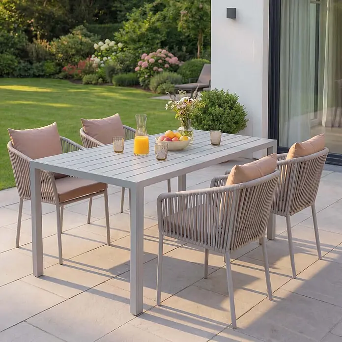 Mendler Gartenmöbel-Set HWC-N41 - 5 -tlg., Metall, Grau, taupe, Grau Kissen taupe - Hellgraue Outdoor-Essgruppe mit rechteckigem Tisch und vier geflochtenen Stühlen mit beigen Kissen auf einer Terrasse.