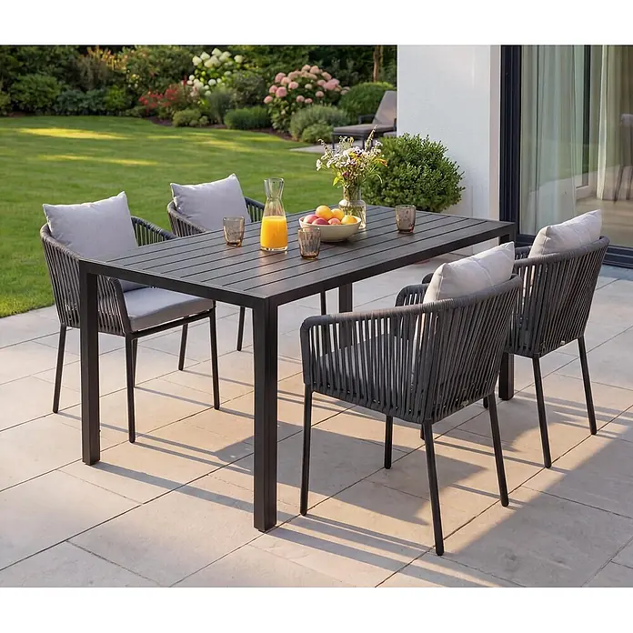 Mendler Gartengarnitur HWC-N41 Tisch+4xStuhl - anthrazit Kissen grau -  - Dunkelgraue Terrassen-Essgruppe mit rechteckigem Tisch und vier geflochtenen Stühlen mit hellgrauen Kissen auf einer Terrasse.