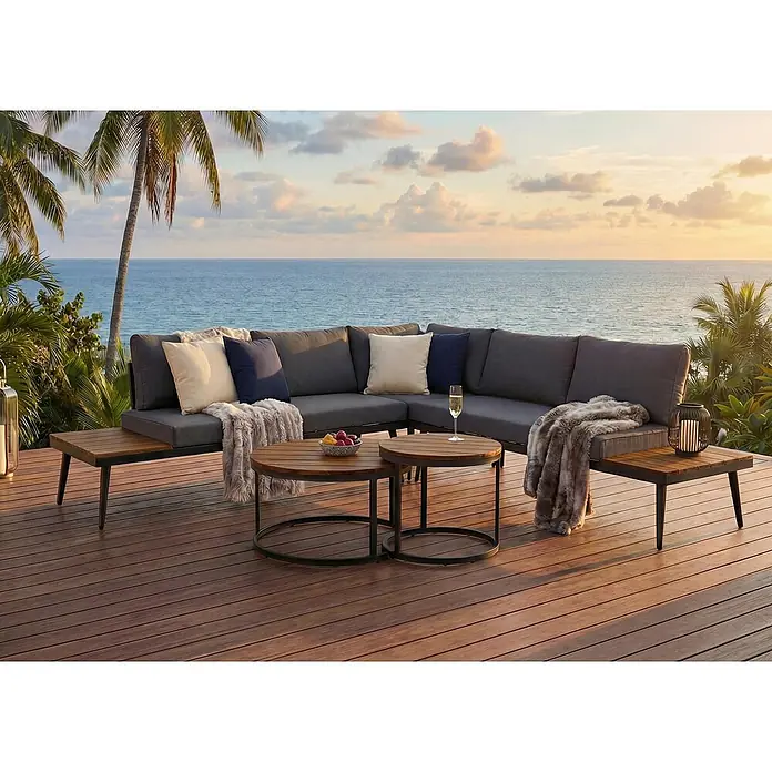Mendler Loungemöbel-Set HWC-H54 - 3 -tlg., Holz, Braun, Kissen dunkelgrau, Braun, dunkelgrau - Ein elegantes, dunkelgraues Outdoor-Sofa mit Holznebentischen und zwei runden Couchtischen aus Holz, auf einer Terrasse mit Meerblick bei Sonnenuntergang.