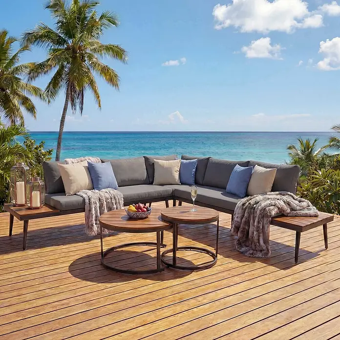 Mendler Loungemöbel-Set HWC-H54 - 3 -tlg., Holz, Braun, Kissen dunkelgrau, Braun, dunkelgrau - Graues Outdoor-Ecksofa und Holztische auf einer Terrasse mit Meerblick.