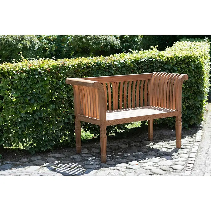 Bene Living Gartenbank Newport - Teakholz, Natur - Gartenbank aus Natur-Teakholz mit Lattenrost-Design auf einem Kopfsteinpflasterweg neben einer grünen Hecke.