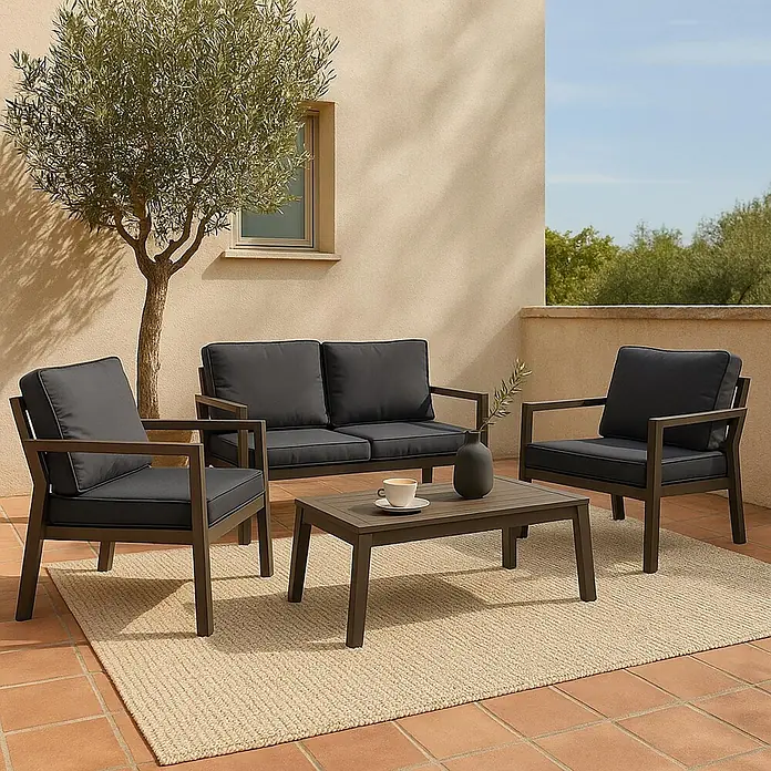 Mendler Loungemöbel-Set HWC-L64 - 4 -tlg., Metall, Polster grau, Grau - Dunkelgraue Outdoor-Sitzgruppe mit Sofa, zwei Stühlen und Couchtisch auf einer Terrasse mit Teppich.