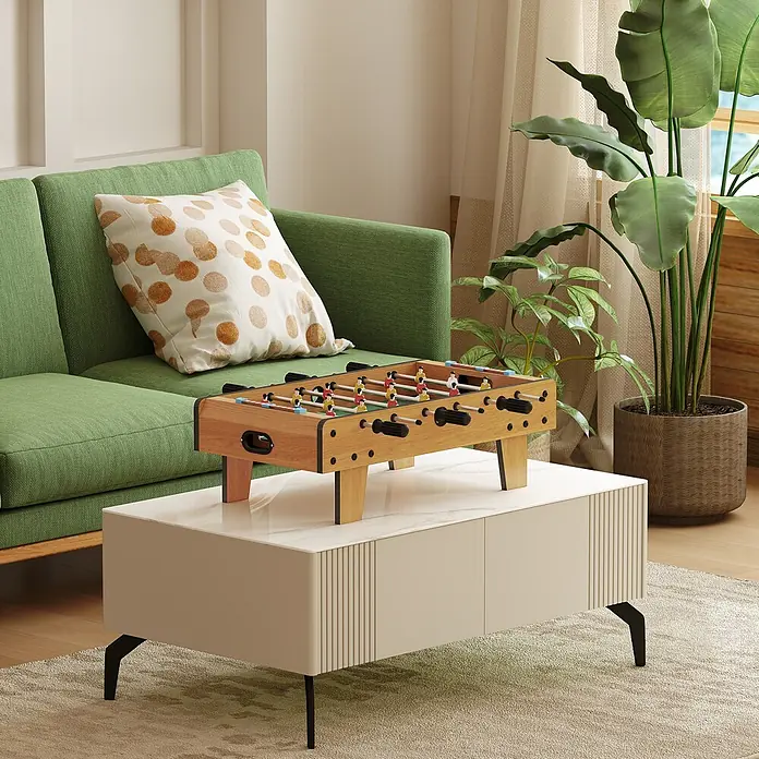 Homcom Tischkicker - L x B x H: 69 x 36,5 x 22 cm, Naturholz - Ein Tischfußballspiel aus Naturholz mit bunten Spielern und schwarzen Griffen, auf einem weißen Couchtisch in einem Wohnzimmer.