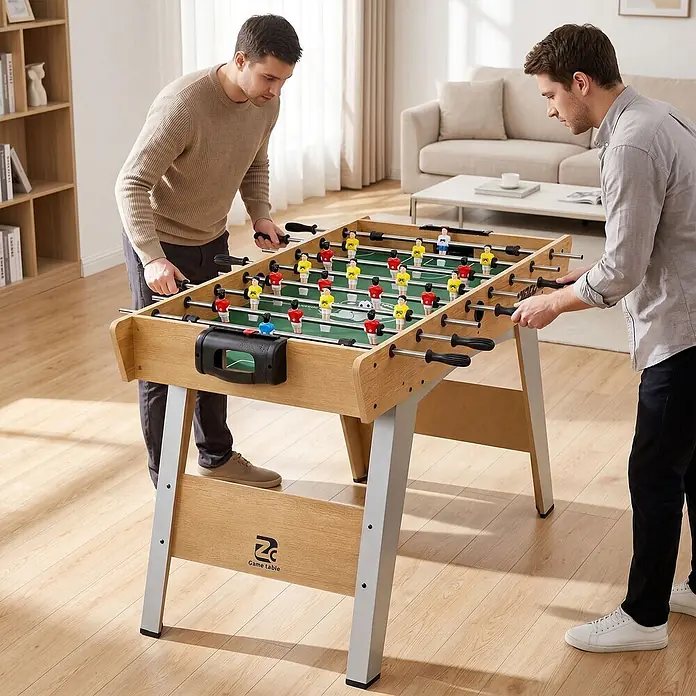 Sportnow Tischkicker - L x B x H: 121 x 87 x 77 cm, Naturholz - Zwei Männer spielen an einem hellbraunen Kicker-Tisch mit schwarzen Griffen und grauen Beinen.