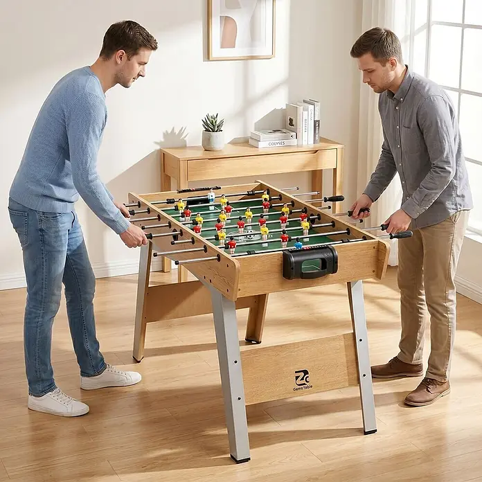 Sportnow Tischkicker - L x B x H: 121 x 87 x 77 cm, Naturholz - Zwei Männer spielen an einem hellen Holzkicker mit grauen Beinen.