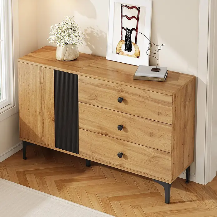 SONNENH Kommode - Natur/Schwarz, Anzahl Schubladen: 3 Stk. - Holz-Sideboard mit drei Schubladen, einem Schrankfach, schwarzem Wellendetail und schwarzen Beinen, in Wohnzimmerumgebung.