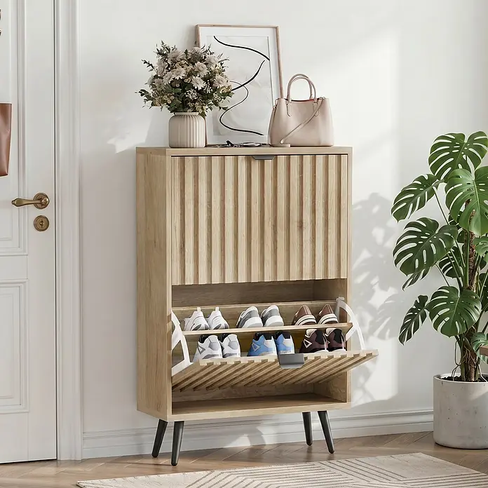 SONNENH Schuhschrank - Holzoptik - Heller Holz-Schuhschrank mit geriffelten Schubladen und schwarzen Beinen, mit Schuhen im Eingangsbereich.