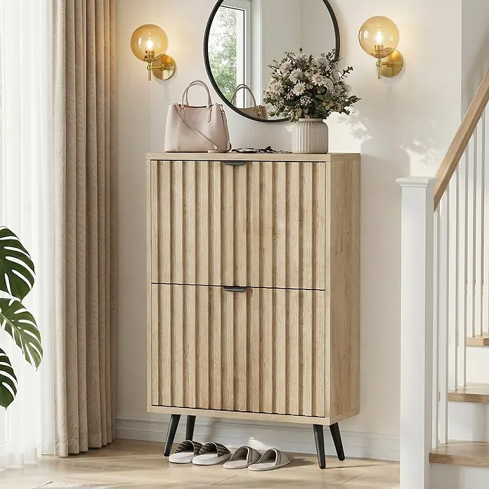 SONNENH Schuhschrank - Holzoptik - Heller Holzschuhschrank mit geriffelten Türen, schwarzen Griffen und Beinen, in einem Flur mit Dekoartikeln oben und Hausschuhen unten.