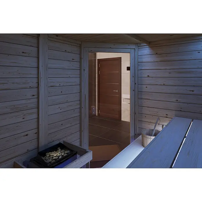 Karibu Elementsauna Corner - Mit Ofen, L x B x H: 170 x 196 x 202 cm - Saunainnenraum aus Holz mit Ofen, Bank und offener Tür zu einem gefliesten Raum.