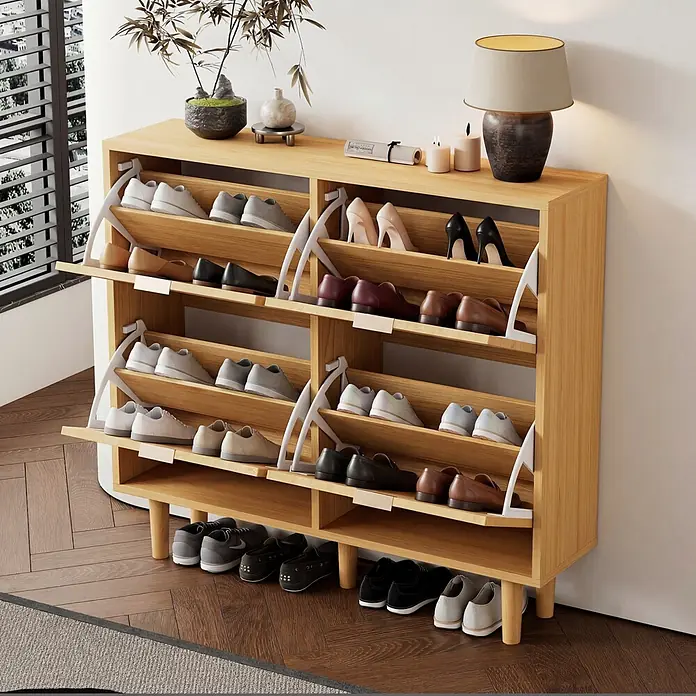 SONNENH Schuhschrank - Helle Eichenoptik - Ein heller Holzschuhschrank mit mehreren Kippfächern enthält verschiedene Schuhe und ein offenes Regal unten für weitere Paare.