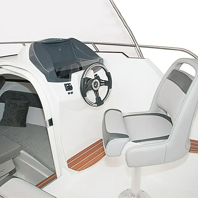 PEGAZUS GFK-Boot 550 Ready to Go 100 - Motorleistung: 73,6 kW, Geeignet für: Max. 6 Personen, Norm: CE-Klasse C - Innenaufnahme eines Bootes mit Steuerrad, Sitz und Kabine. Die Kabine hat graue Polster, während der Sitz grau-weiß ist.